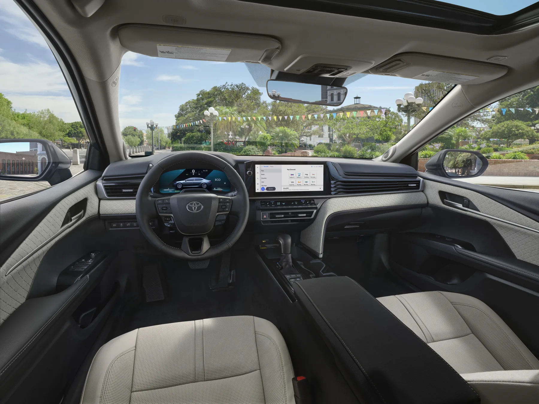 Cabin of a 2025 Toyota Camry, dash, wheel, and front seats