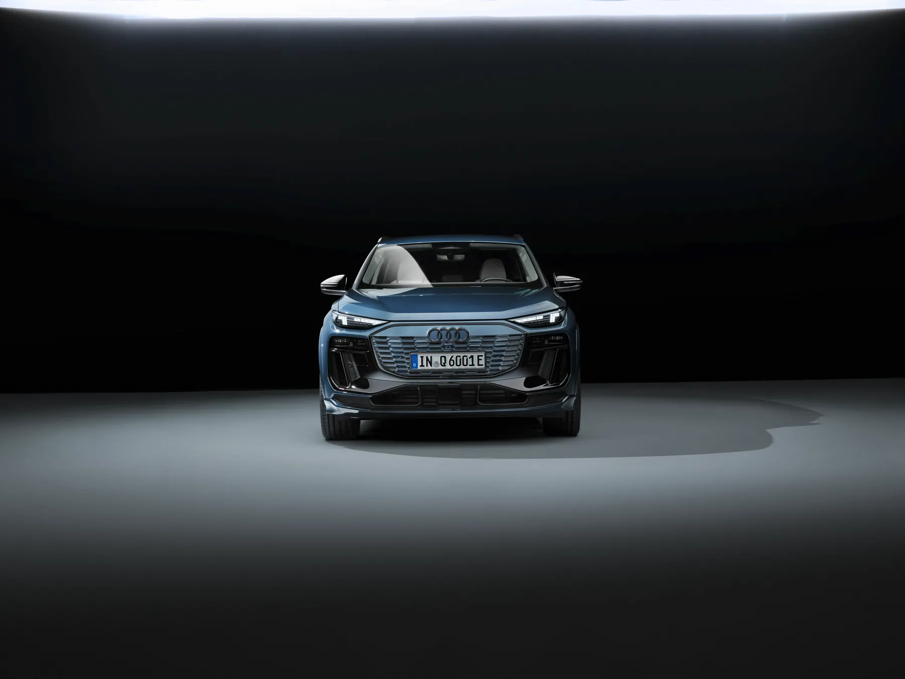 Blue 2026 Audi Q6 e-tron, studio front with closed Singleframe and split lamps