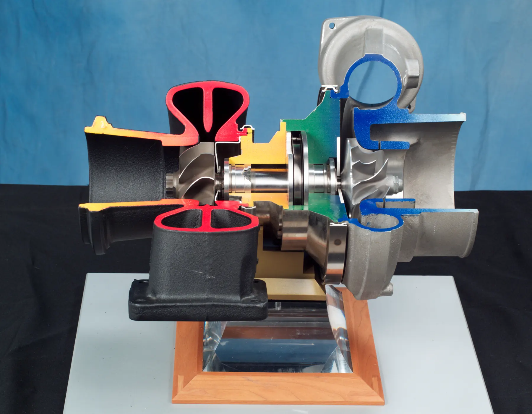 Color-coded turbocharger cutaway with turbine and compressor wheels on one shaft